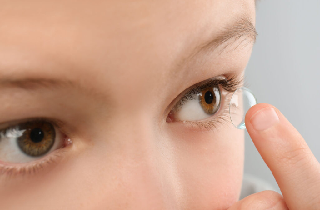 A young child inserting MiSight contact lenses to help slow the progression of myopia.