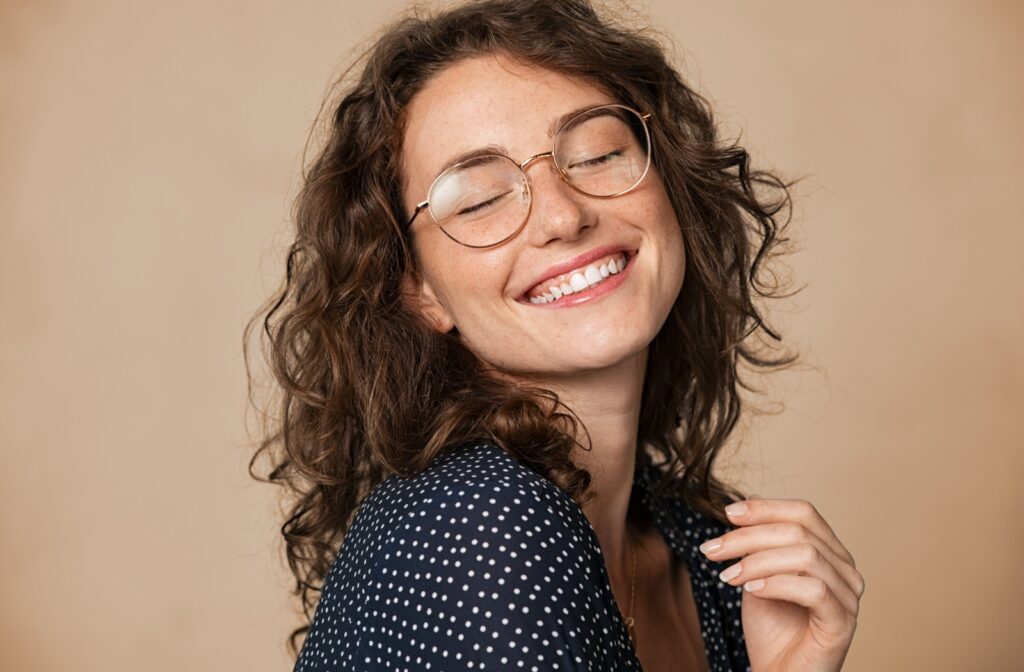 A happy woman wearing a pair of glasses with oversized frames.
