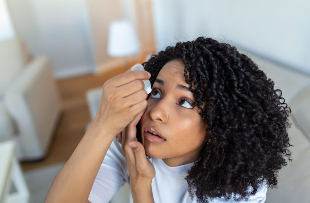 A young adult uses eye drops to alleviate the symptoms of their dry eyes.