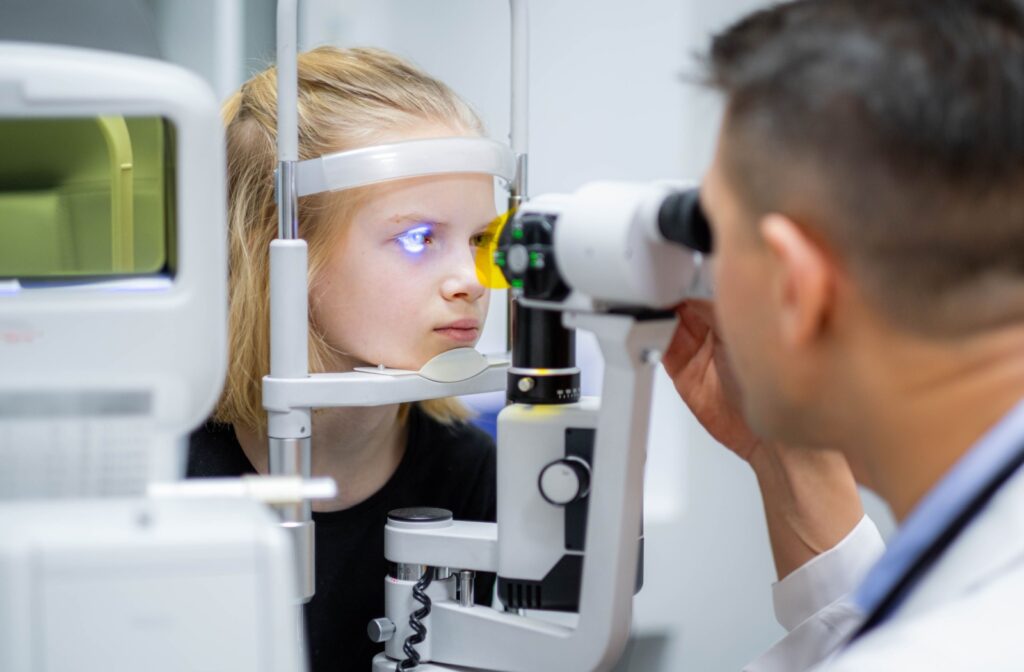 Optometrist performing a slit-lamp eye exam on a young patient to check eye health and vision clarity.