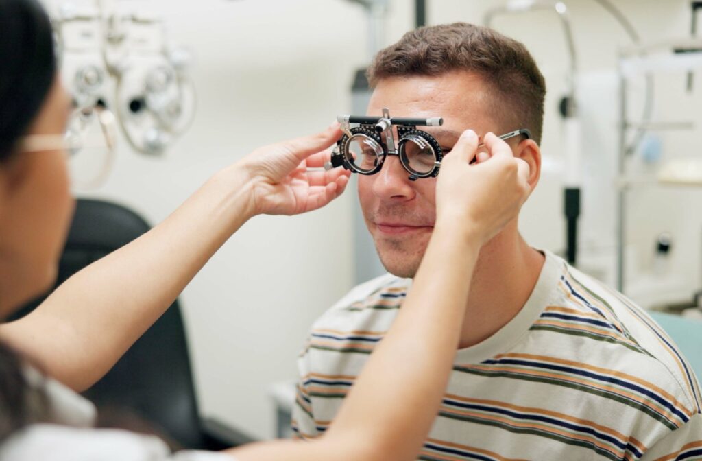 Optometrist holding a diagnostic tool up to a patient's eyes during a comprehensive eye exam.
