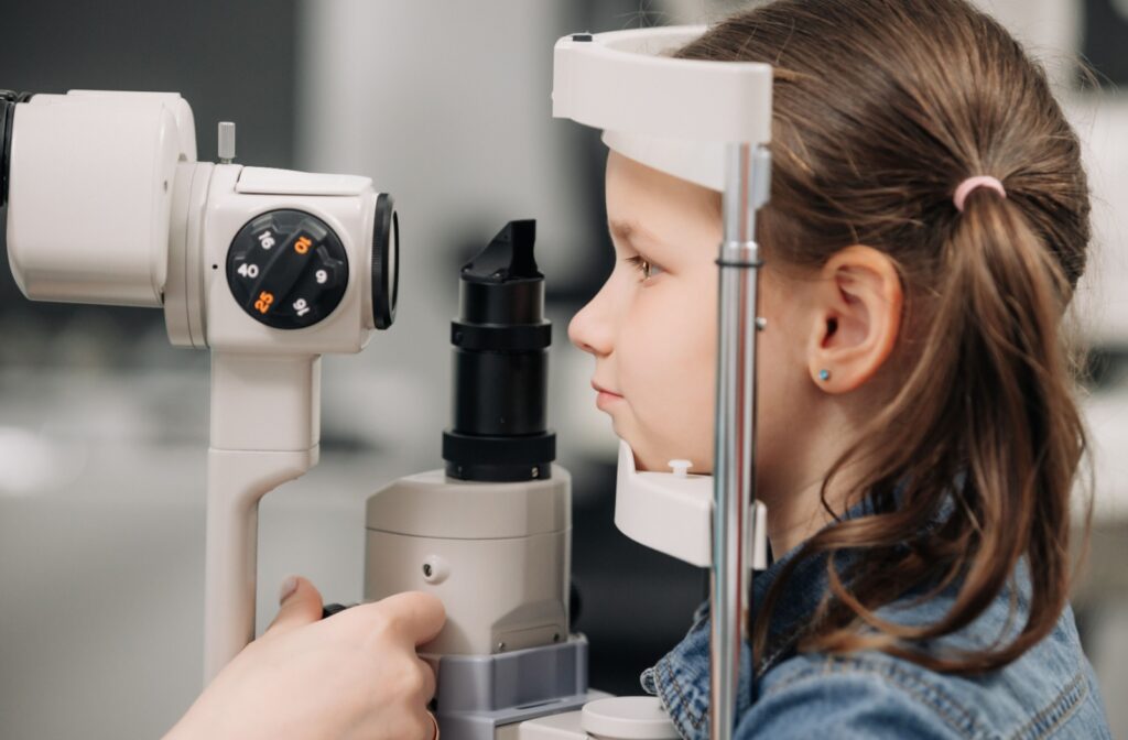 Profile of child undergoing eye exam with chin and forehead positioned in a diagnostic device.